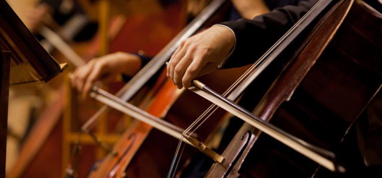 Orchestra players playing cellos